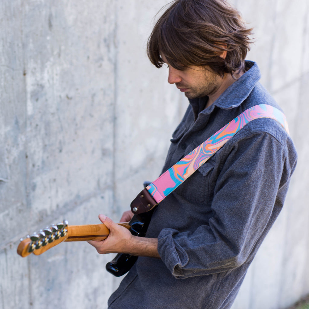 tye dye vibrant electric avenue pink blue orange swirl Nashville guitar strap by original fuzz on model