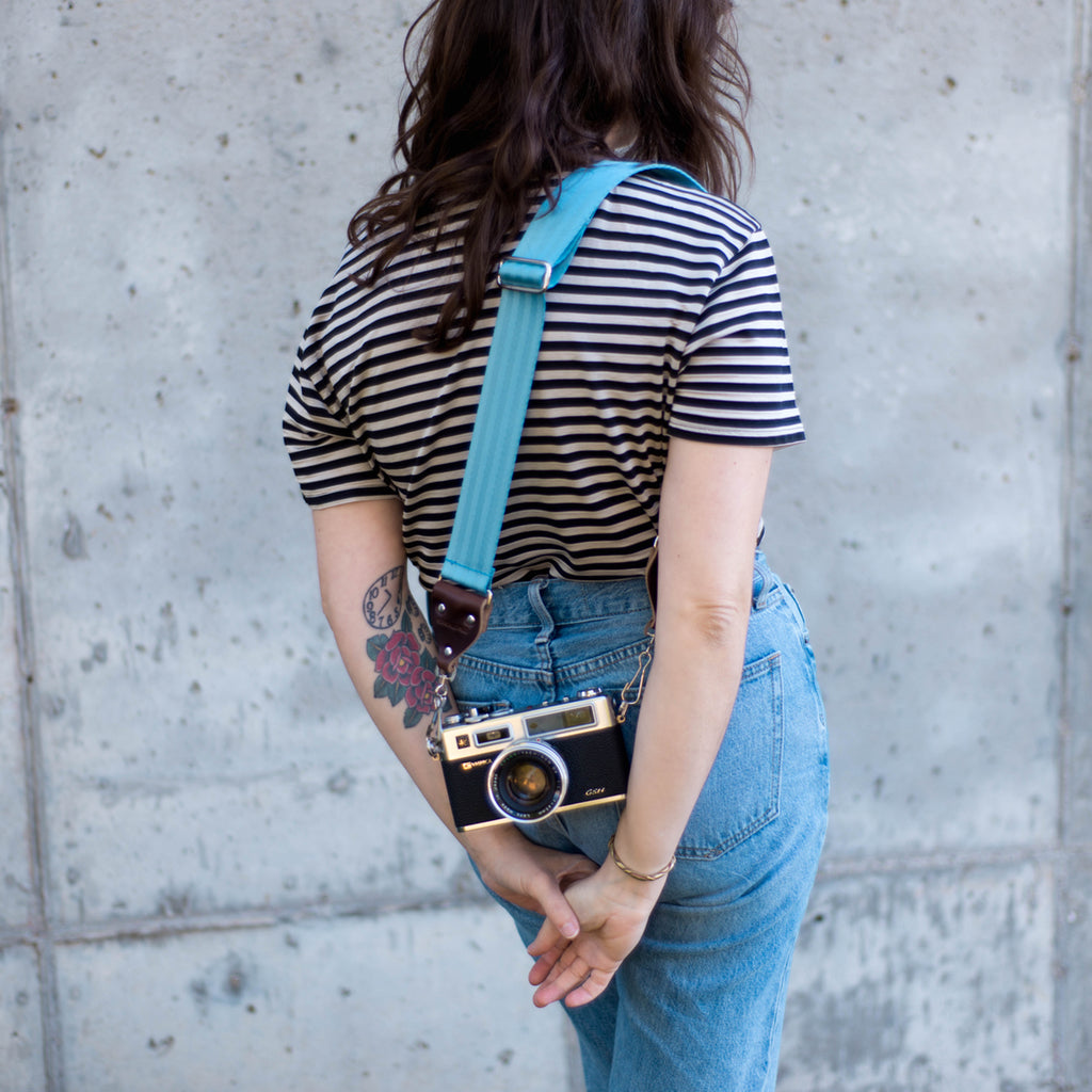 Seatbelt camera outlet strap