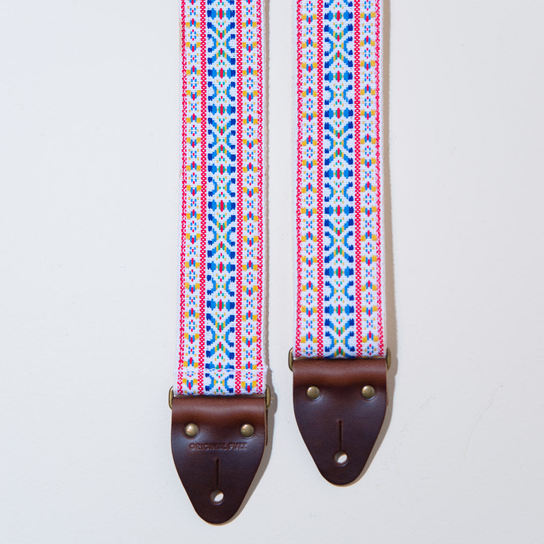 Close-up view of the multi-colored woven jacquard and brown horween leather used in the vintage guitar strap in Hatch blvd
