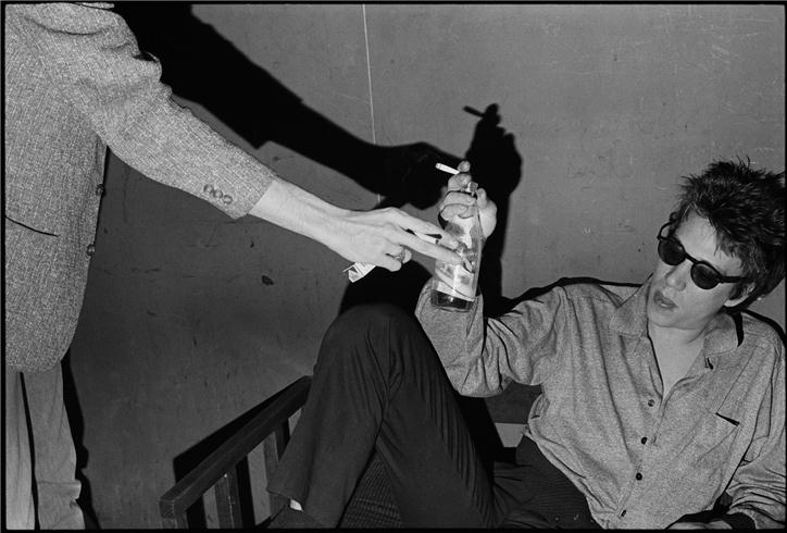 Richard Hell with a cigarette and beer at a punk rock club