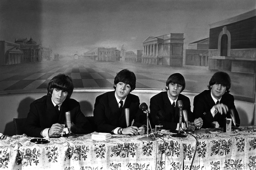 The Beatles at a press conference while on tour in the 60s