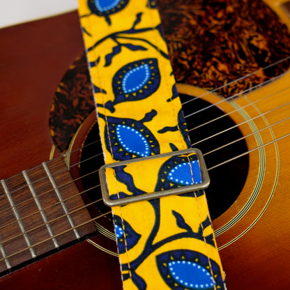 Buckle detail of guitar strap in yellow and blue botanical African wax print fabric with black leather end-tab. Made in Nashville by Original Fuzz.