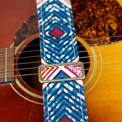 Buckle detail of guitar strap in dark teal, burgundy, cream, and yellow diamond tile African wax print fabric with brown leather end-tab. Made in Nashville by Original Fuzz.