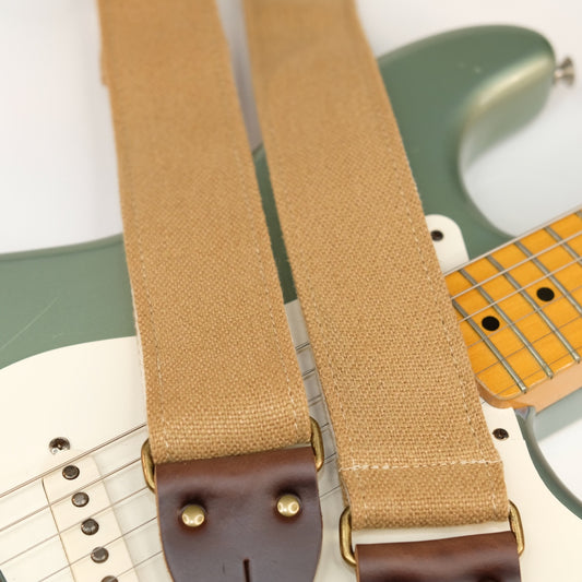 Wide view of guitar strap in tan woven fabric with brown leather end-tab. Made in Nashville by Original Fuzz.