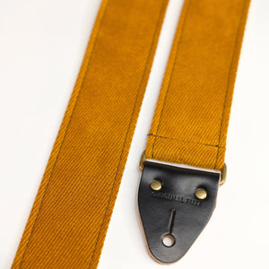 End-tab detail view of guitar strap in golden brown woven fabric with black leather end-tab. Made in Nashville by Original Fuzz.