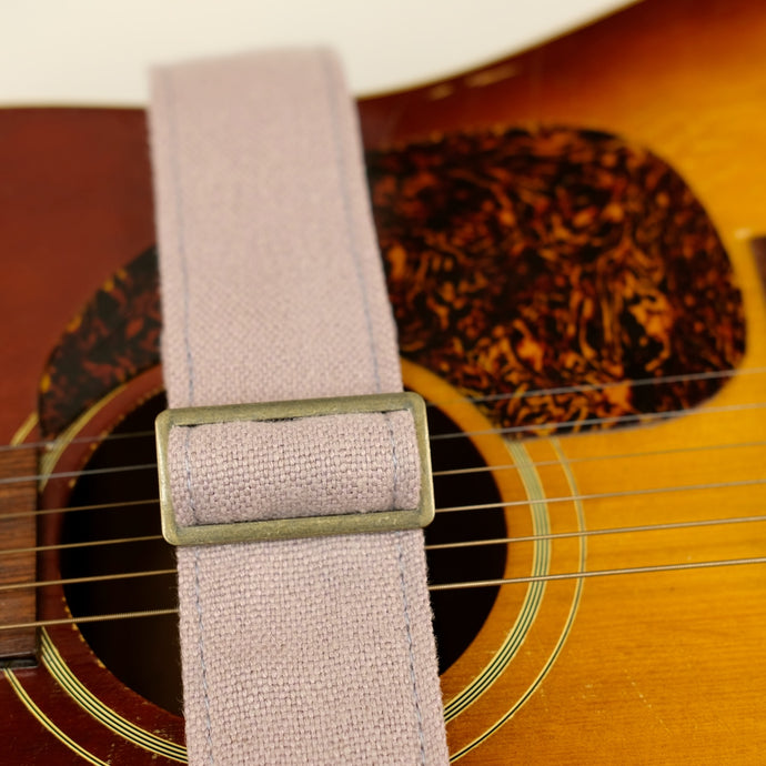 Buckle detail of guitar strap in dusty pink-purple woven fabric with brown leather end-tab. Made in Nashville by Original Fuzz.