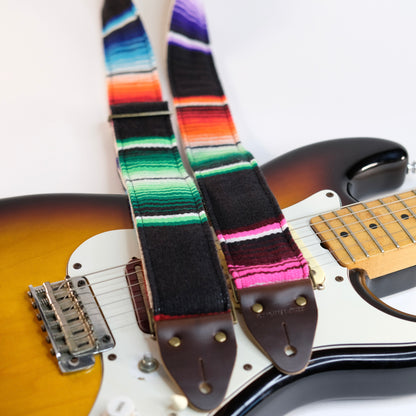 Wide view of guitar strap in black serape fabric with brown leather end-tab. Made in Nashville by Original Fuzz.