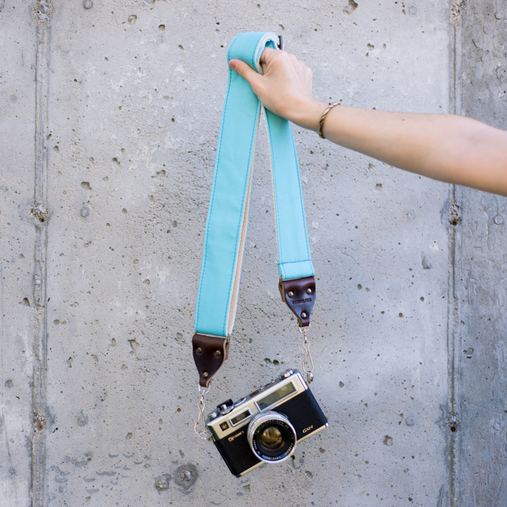 Light arctic blue vintage-style camera strap made by Original Fuzz in Nashville, TN. with a Yashica film camera.