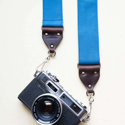 Blue vintage-style cotton canvas camera strap made by Original Fuzz in Nashville with a Yashica film camera.