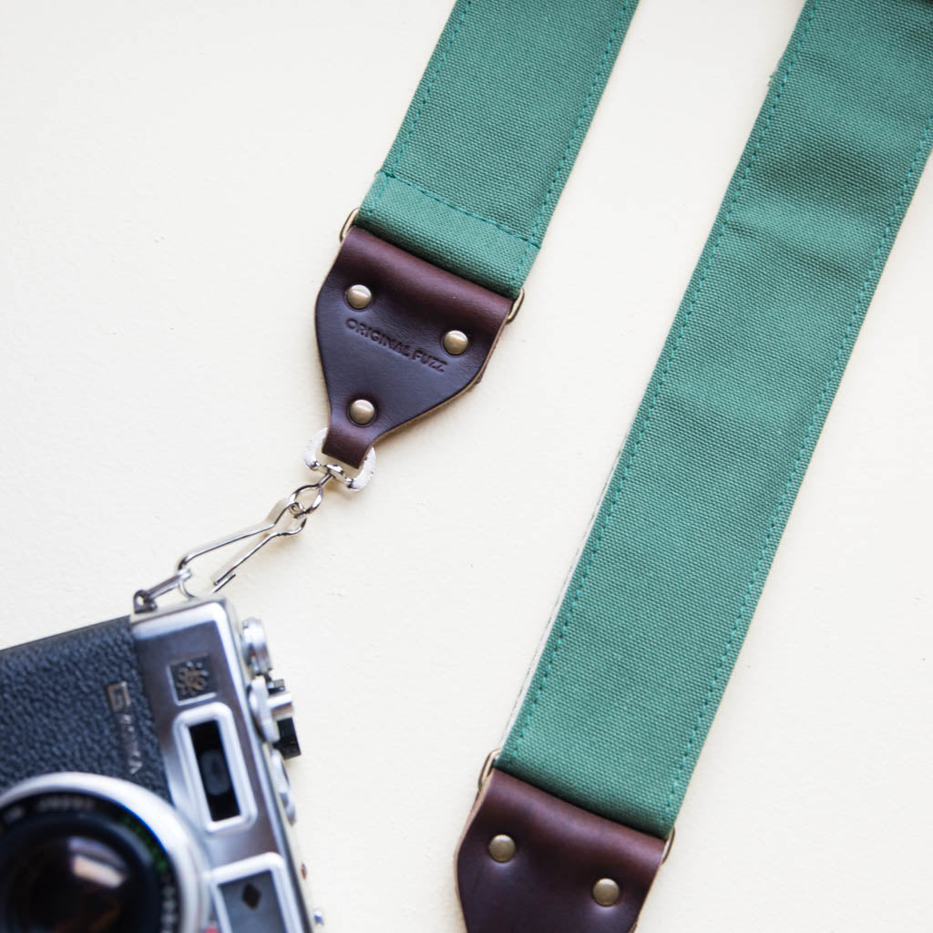 Green cotton canvas vintage-style camera strap with antique brass hardware and vintage Yashica camera made by Original Fuzz.