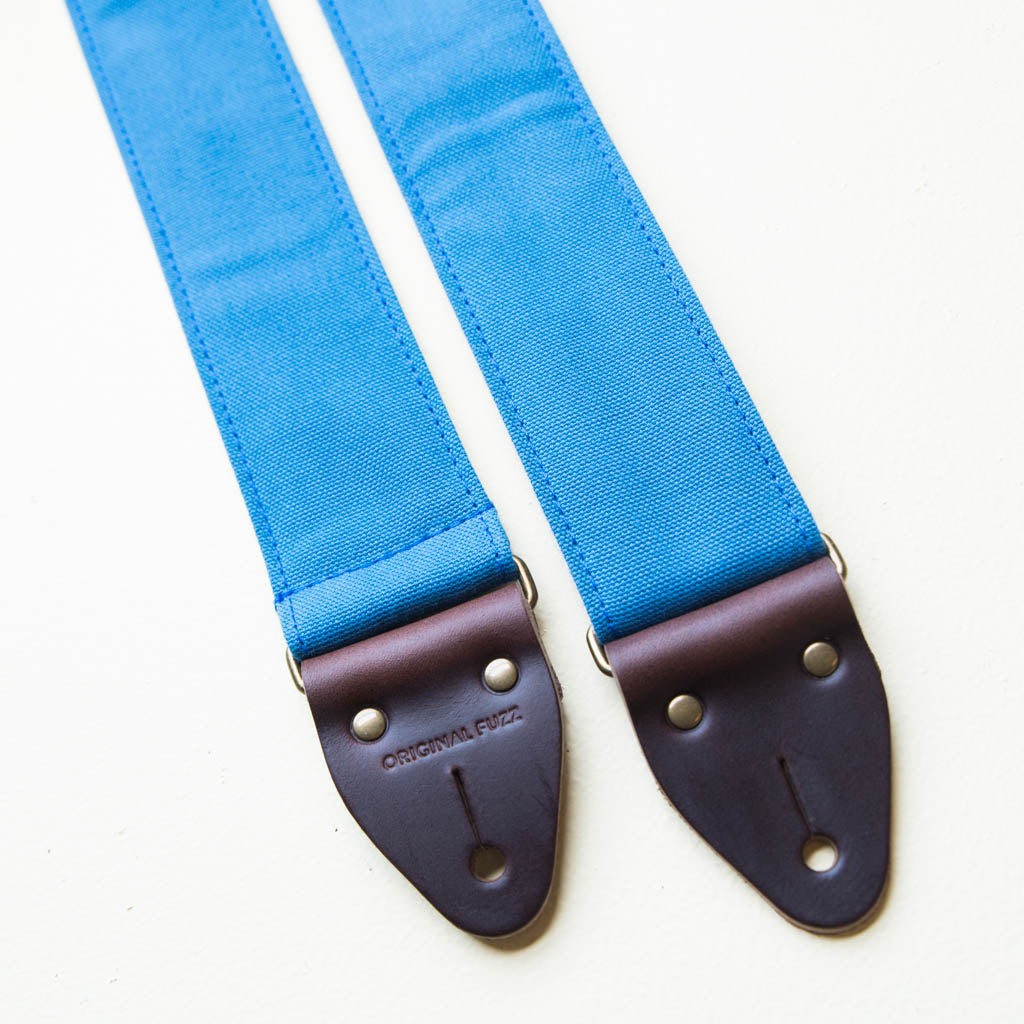 Blue vintage-style cotton canvas guitar strap with antique brass hardware made by Original Fuzz in Nashville.