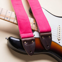Hot pink vintage-style cotton canvas guitar strap made by Original Fuzz with a Fender Jazzmaster.
