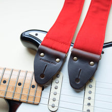 Red cotton canvas vintage-style guitar strap with antique brass hardware made by Original Fuzz in Nashville with a Fender Jazzmaster.