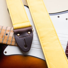 Yellow cotton canvas vintage-style guitar strap with antique brass hardware made by Original Fuzz in Nashville, TN with a Fender Jazzmaster.