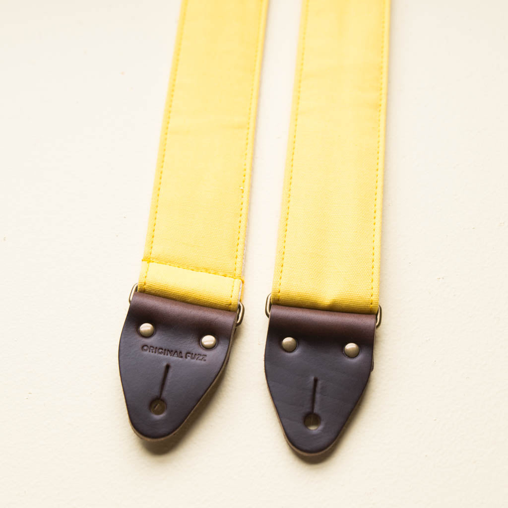 Yellow cotton canvas vintage-style guitar strap with antique brass hardware made by Original Fuzz in Nashville, TN.