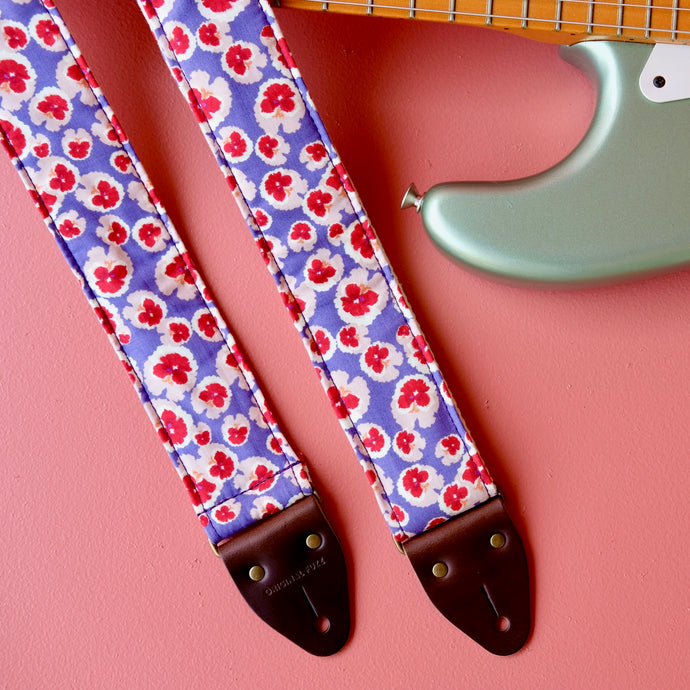 Purple and red classic floral pattern lightweight cotton handmade guitar strap with a Fender guitar. 