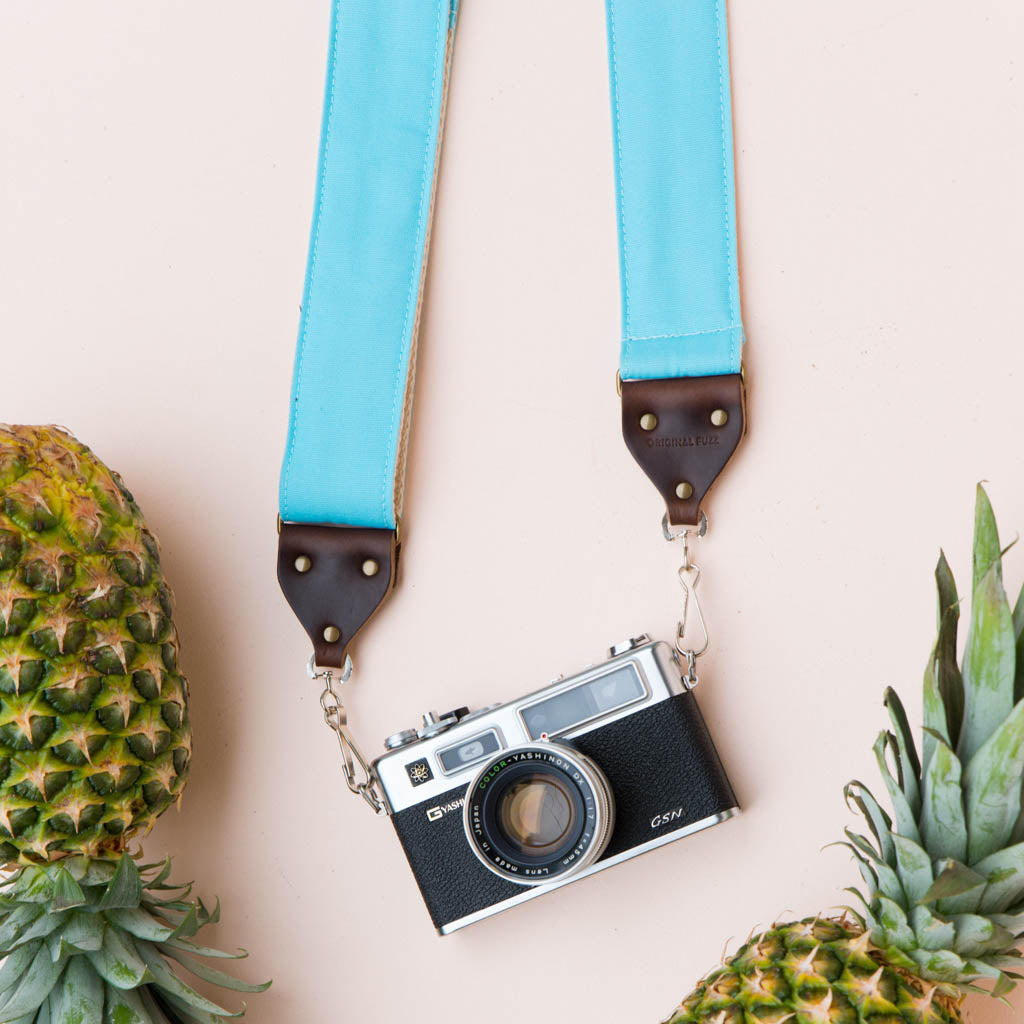 Light arctic blue vintage-style camera strap made by Original Fuzz in Nashville, TN. with a Yashica film camera.