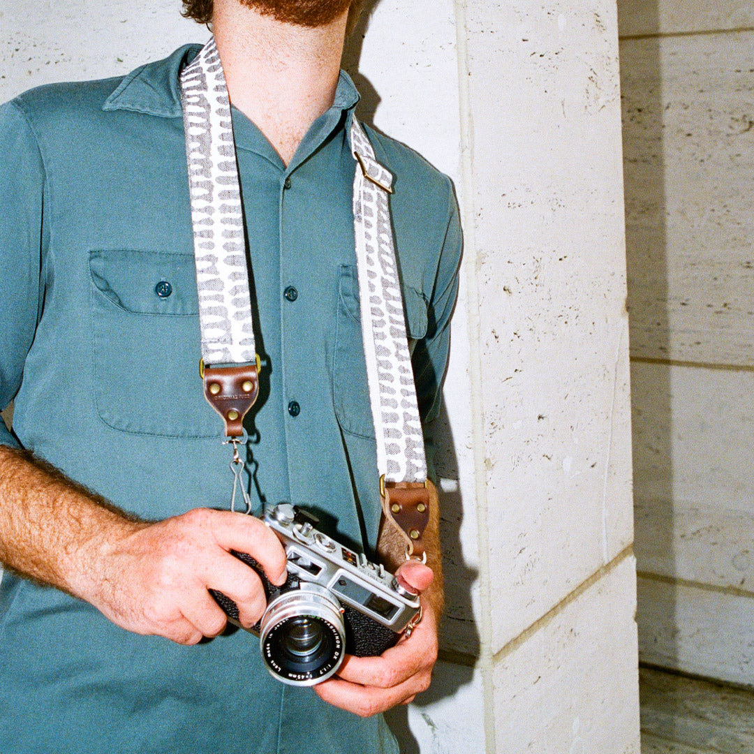 White and gray vintage-style skinny camera strap made with fabric block printed in India by Original Fuzz in Nashville, TN. 