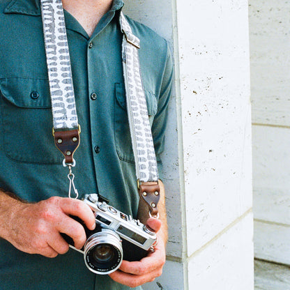 White and gray vintage-style skinny camera strap made with fabric block printed in India by Original Fuzz in Nashville, TN. 