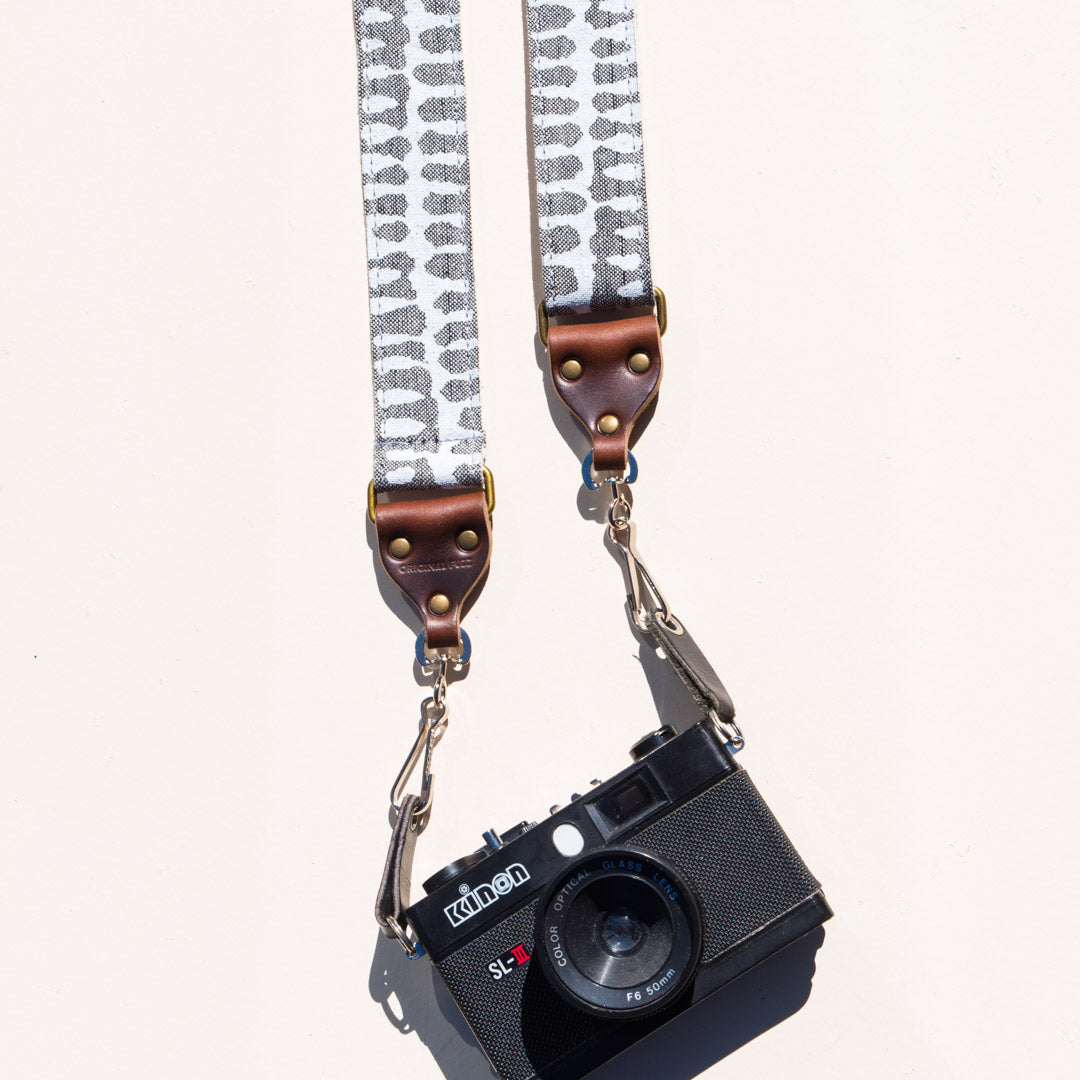 White and gray vintage-style skinny camera strap made with fabric block printed in India by Original Fuzz in Nashville, TN. 