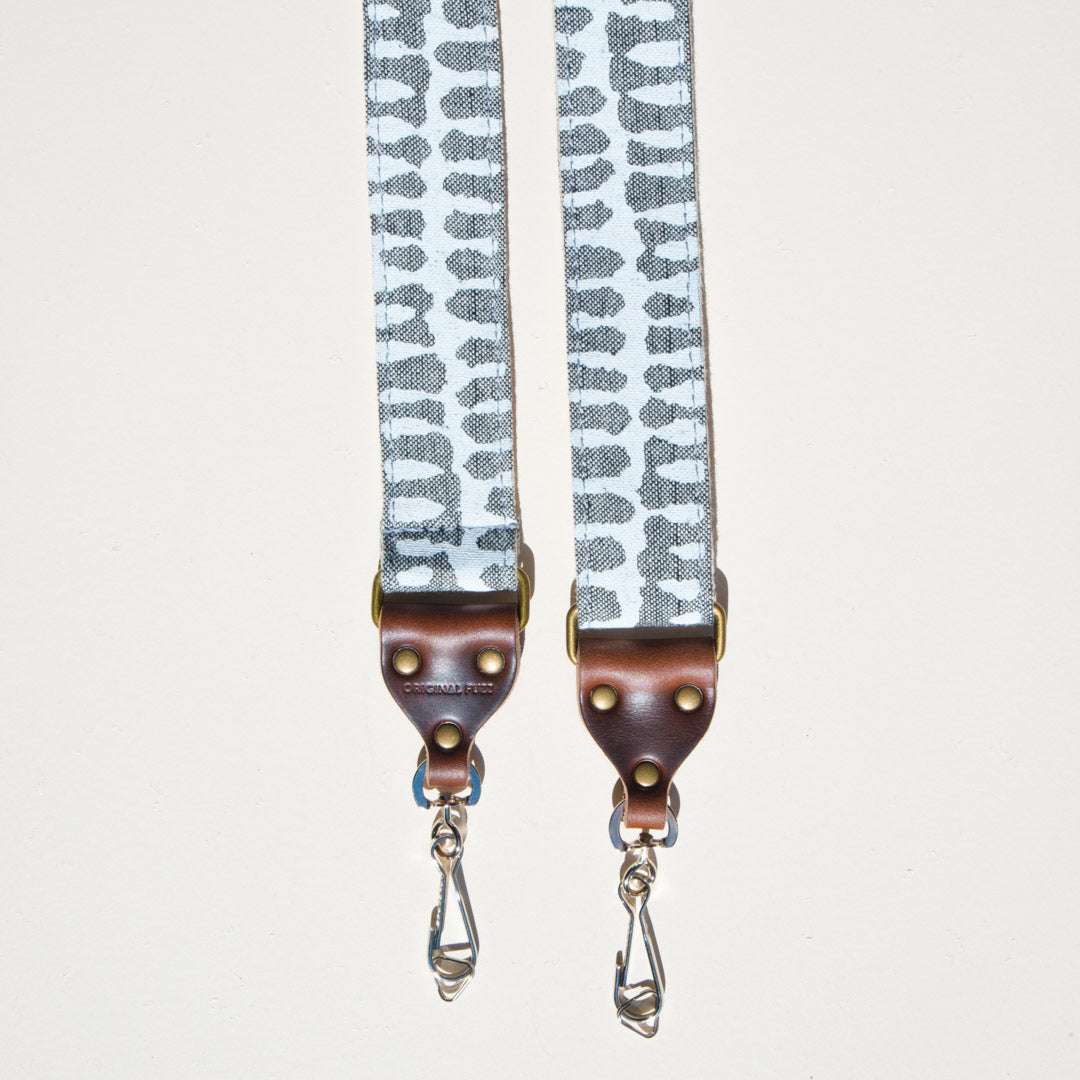 White and gray vintage-style skinny camera strap made with fabric block printed in India by Original Fuzz in Nashville, TN. 