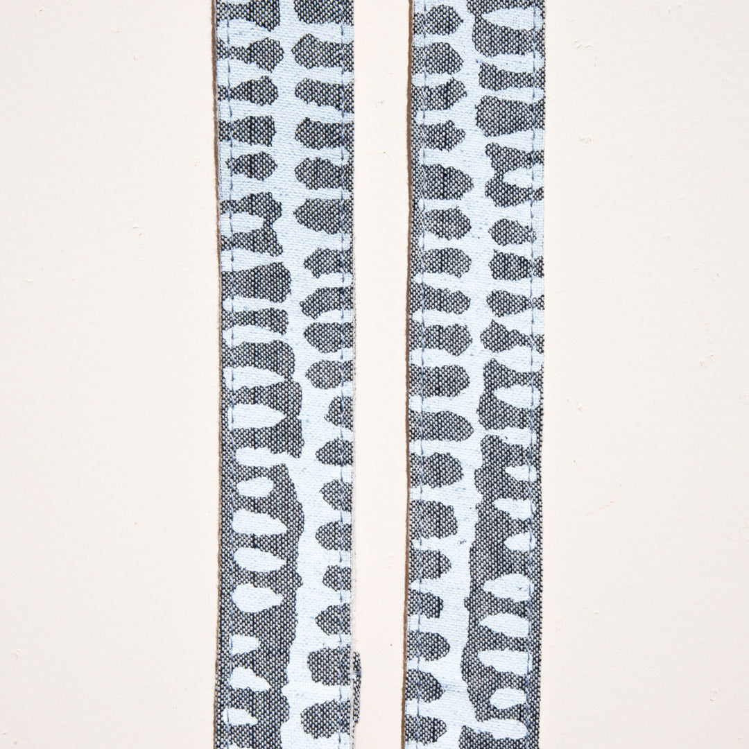 White and gray vintage-style skinny camera strap made with fabric block printed in India by Original Fuzz in Nashville, TN. 