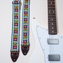 The Vintage Guitar Strap in Rhododendron Ave with a white Fender Jaguar